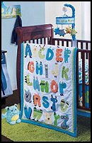 Alpha Baby 5-Piece Set includes comforter, dust ruffle, fitted crib sheet, diaper stacker, and window valance.